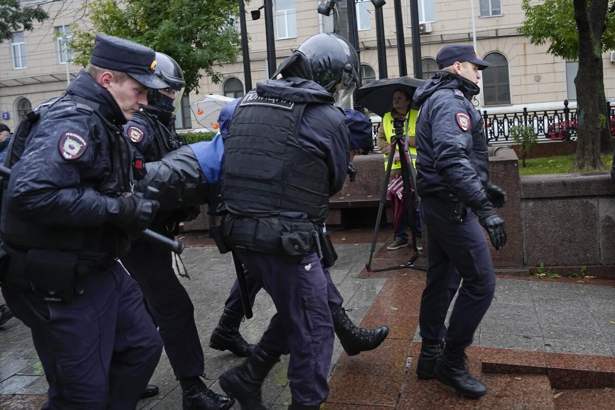 Varios policías cargan a un manifestante detenido durante una protesta contra una movilización parcial
