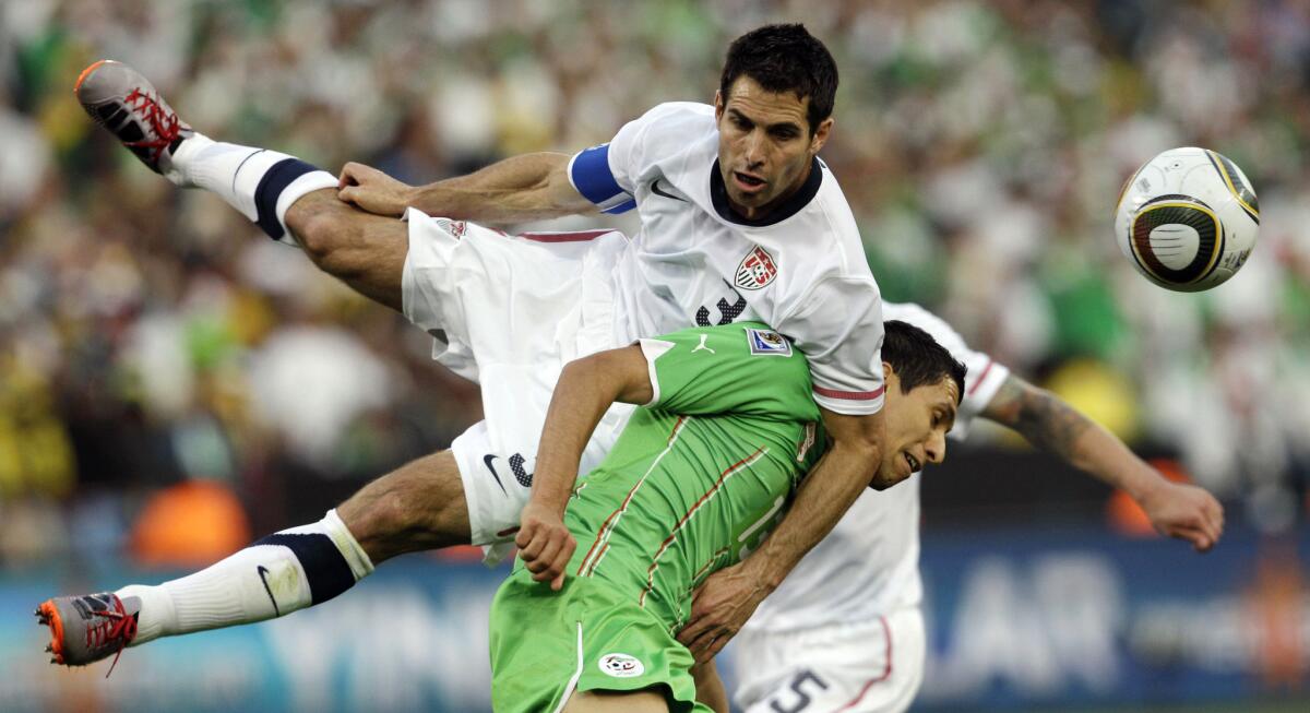 U.S. defender Carlos Bocanegra, top, competes for the ball with Algeria's Karim Matmour during a World Cup soccer game in Pretoria, South Africa, in 2010.