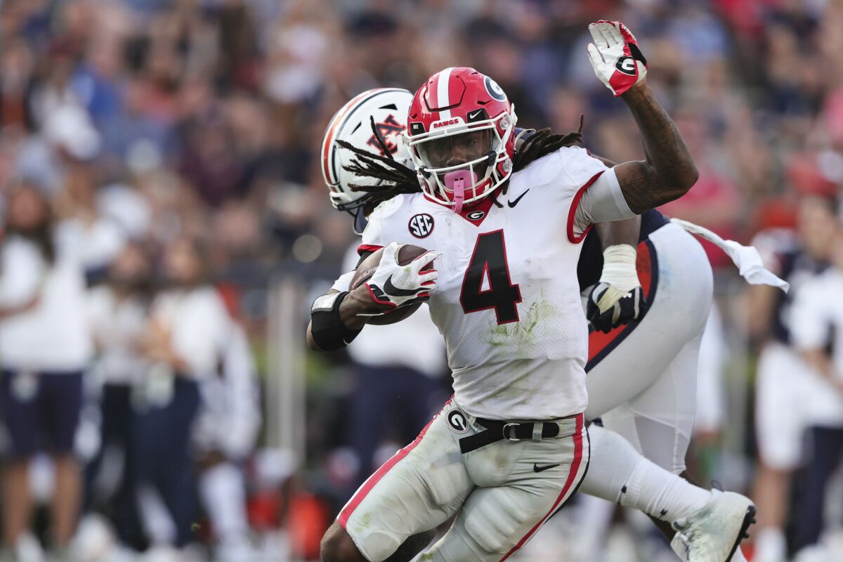 Georgia running back James Cook (4) carries the ball against Auburn during the second half of an NCAA college football game Saturday, Oct. 9, 2021, in Auburn, Ala. (AP Photo/Butch Dill)