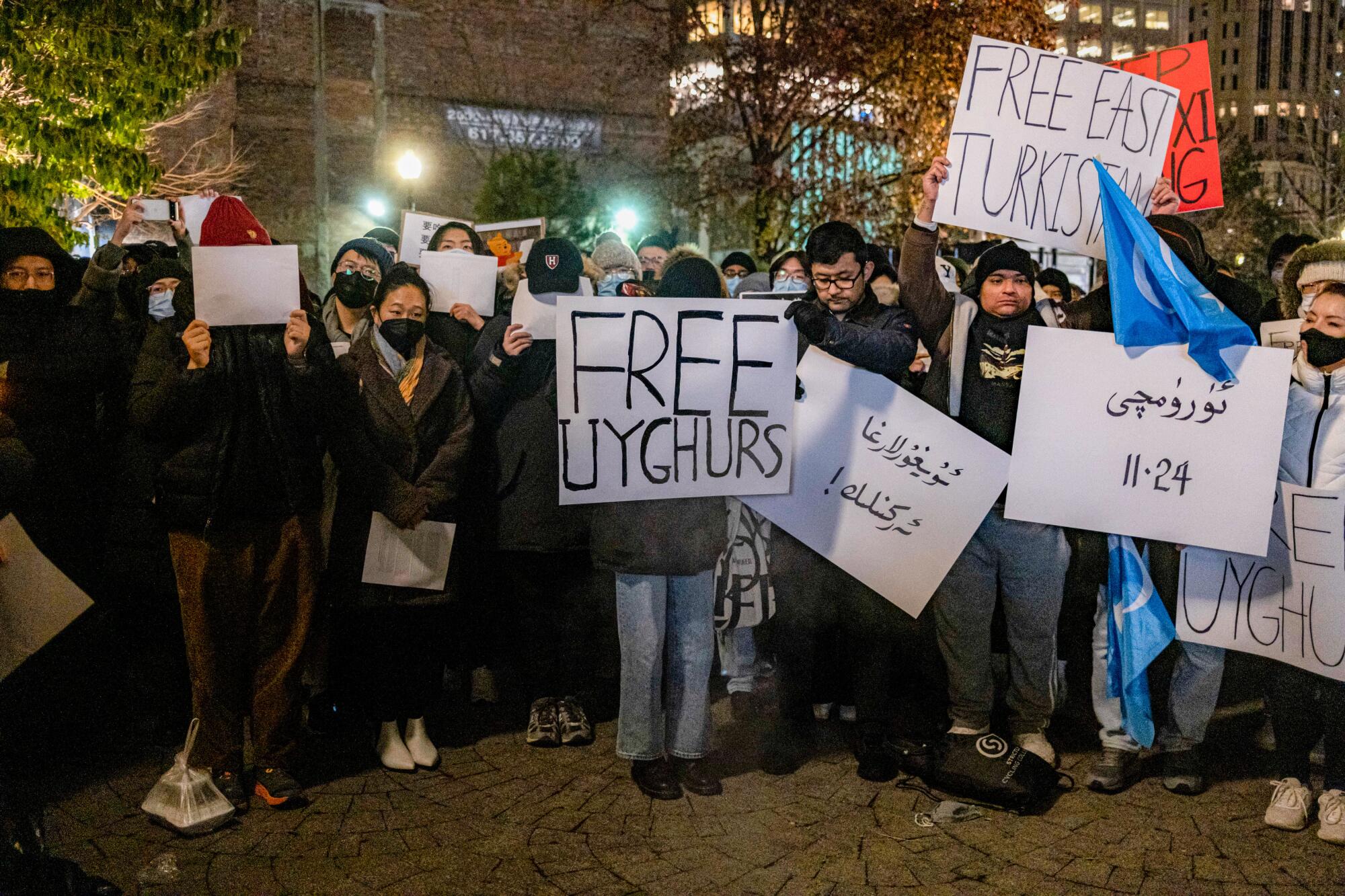 Demonstrators hold placards that read "Free Uyghurs" and "Free Turkistan" during a protest in Boston.