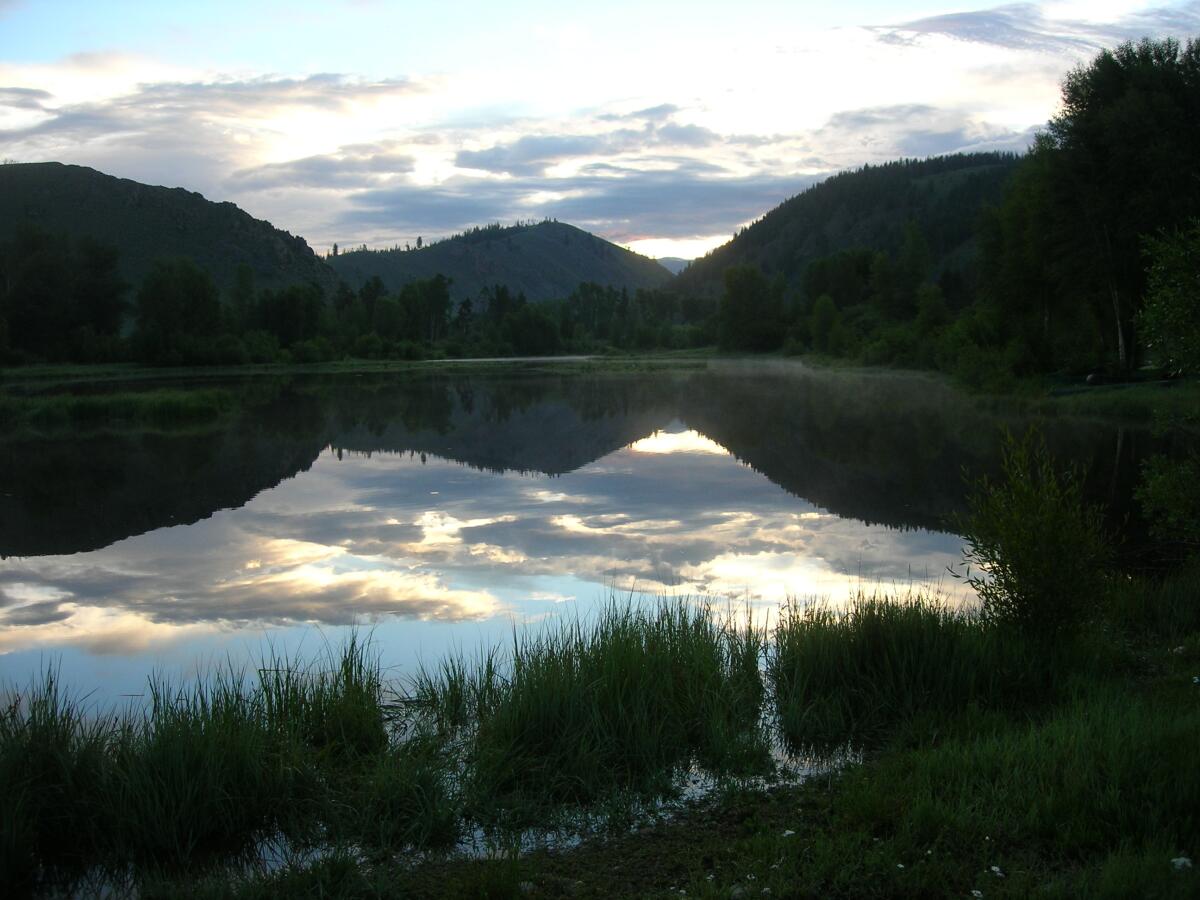 A mountain lake with clouds reflected on its surface