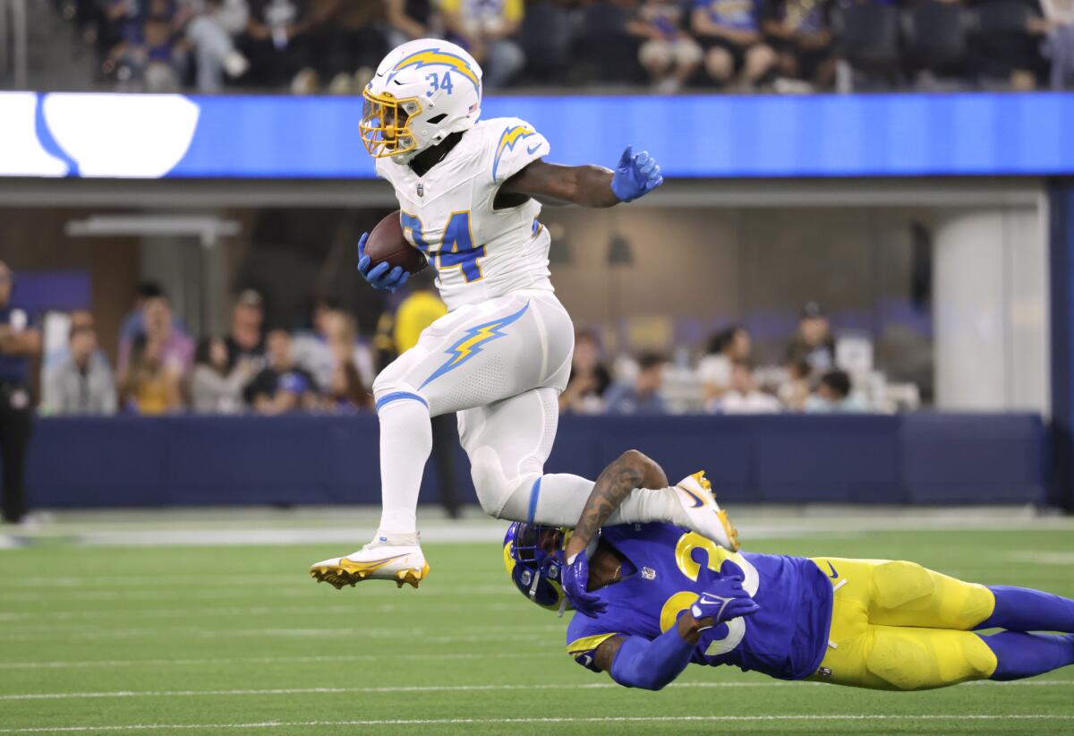Chargers running back Larry Rountree III slips away from Rams' Rashad Torrence and gains a first down.