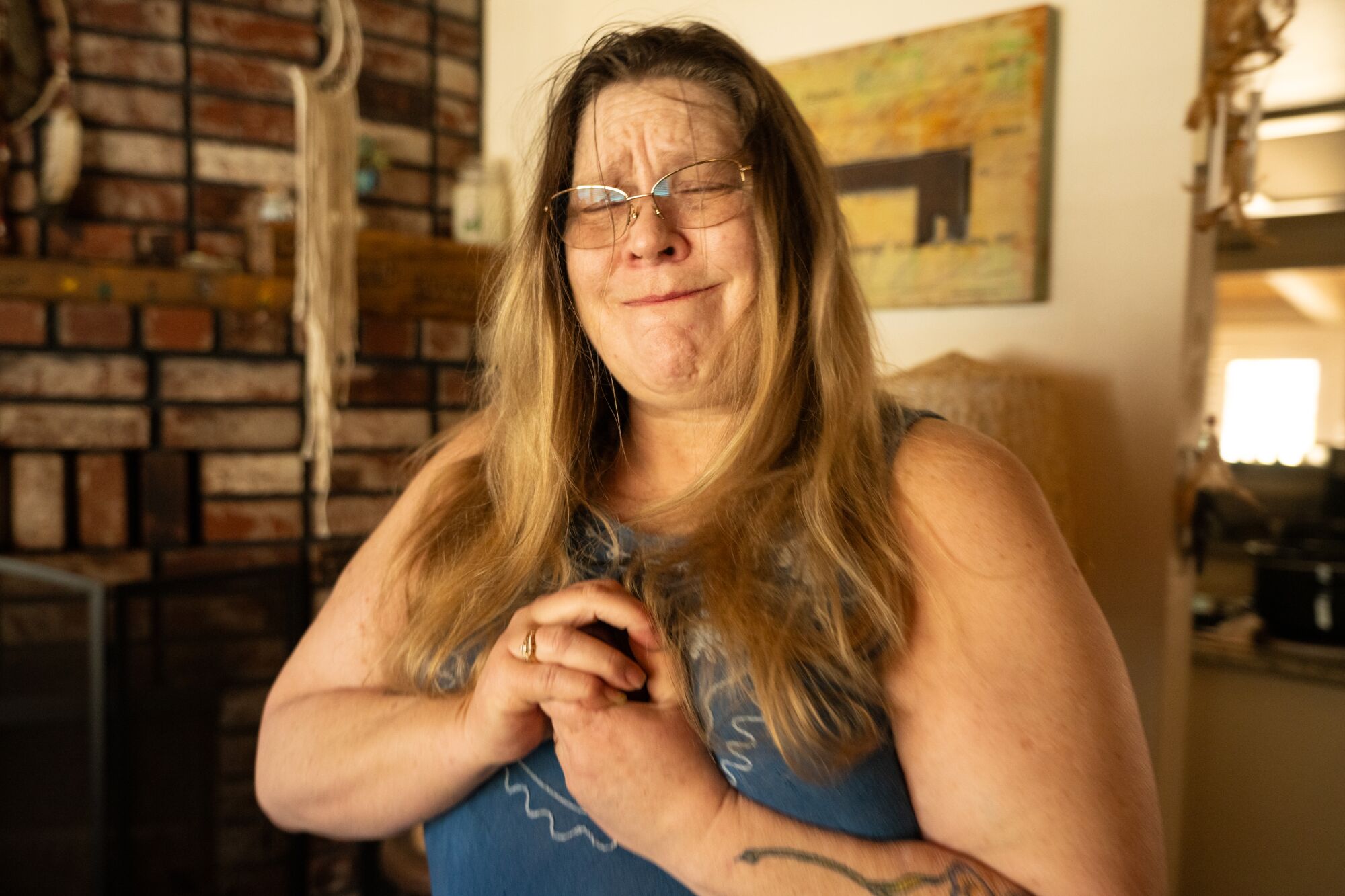 A woman gets emotional as she holds the ashes of her mother in a heart urn.