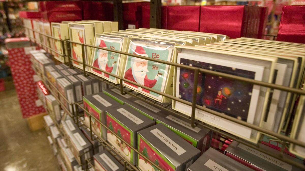 Christmas and holiday cards are displayed on a rack for sale.
