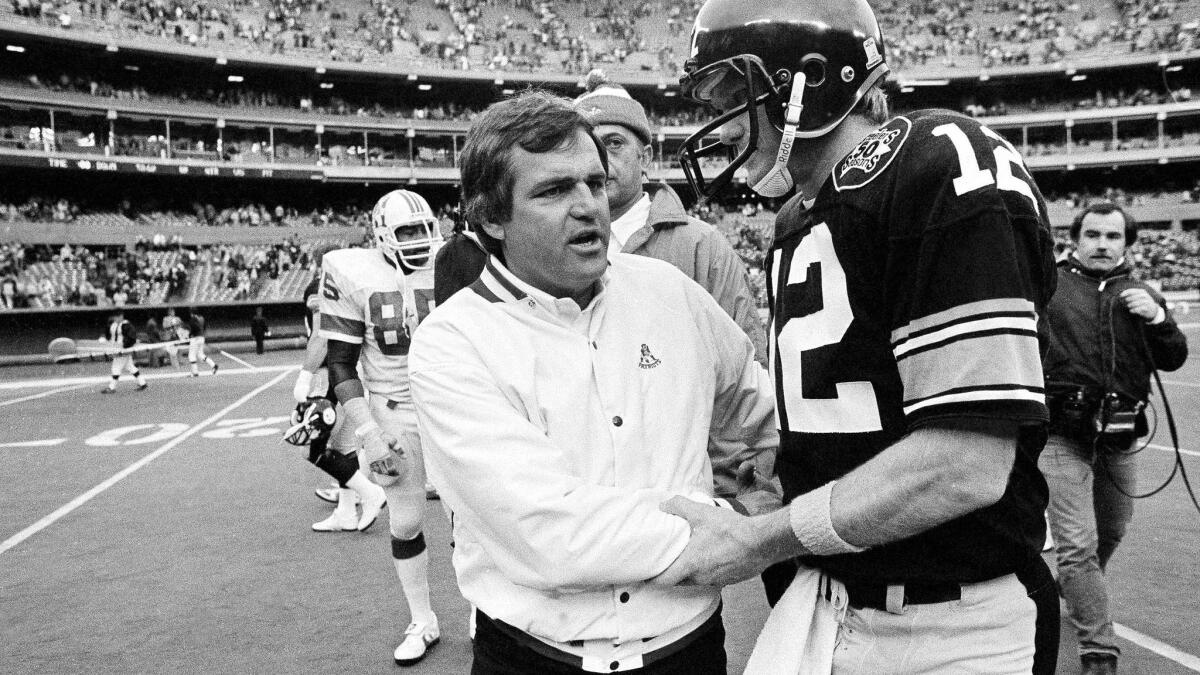 New England Patriots coach Ron Meyer congratulates Steelers quarterback Terry Bradshaw after Bradshaw led his team to a 37-14 win to clinch a spot in the playoffs.