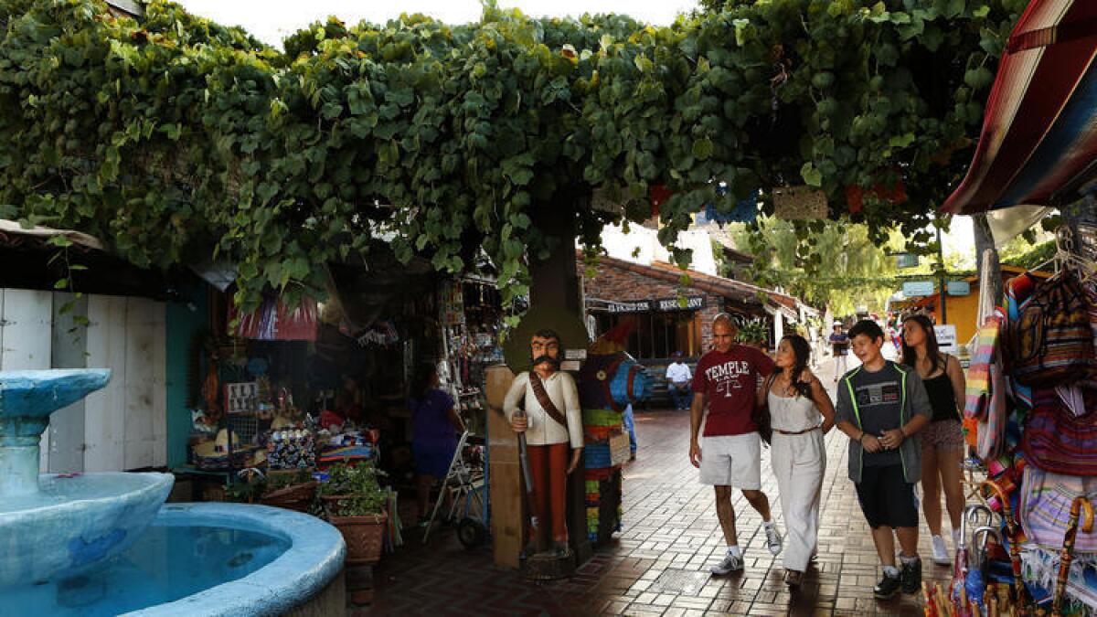 Los visitantes pasean a lo largo de la Calle Olvera, parte del Monumento Histórico El Pueblo de Los Angeles localizado en el centro de Los Angeles.