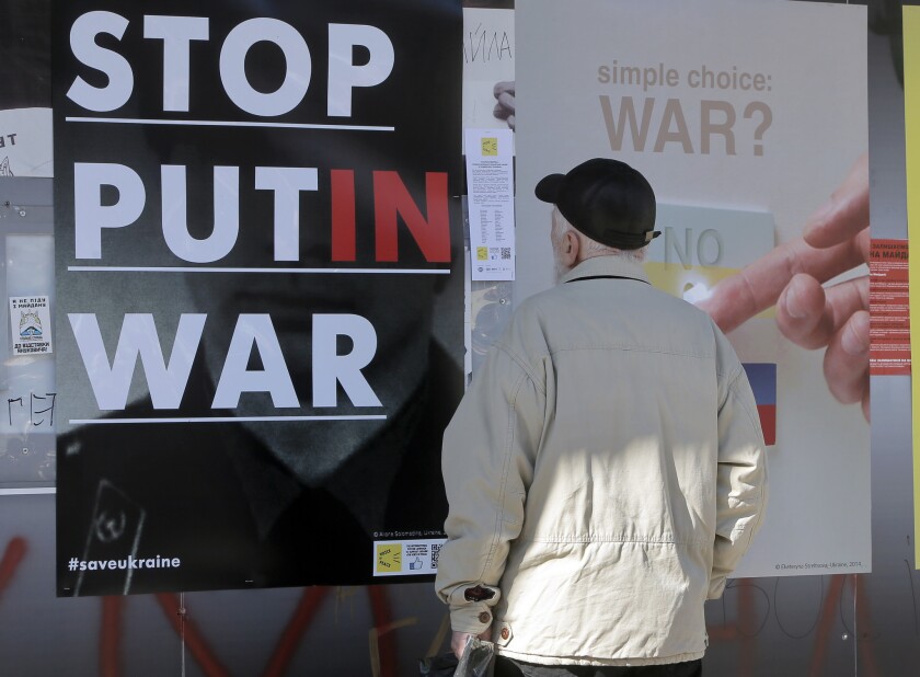 A man looks at anti-Putin posters in Kiev, Ukraine.