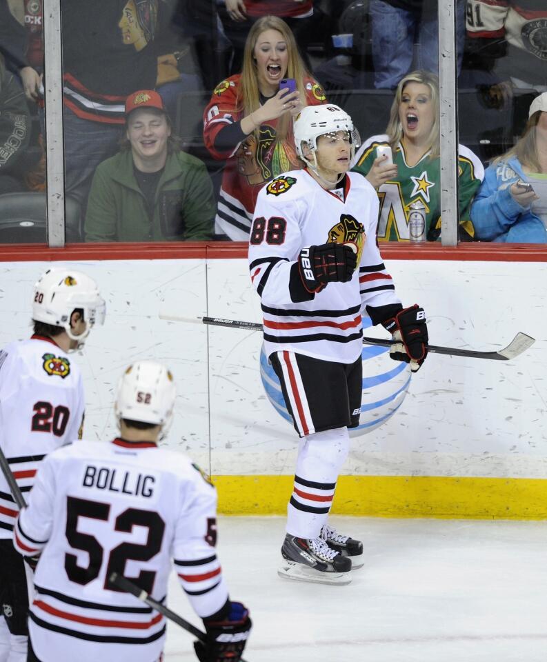 Patrick Kane celebrates a goal against the Wild as Brandon Saad and Brandon Bollig look on during the third period.