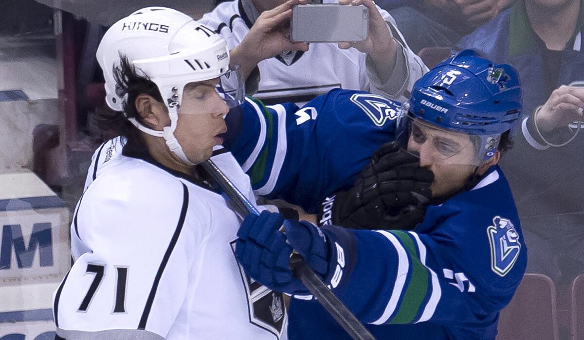 Kings forward Jordan Nolan (71) and Canucks defenseman Luca Sbisa battle along the boards in the first period Thursday night in Vancouver.