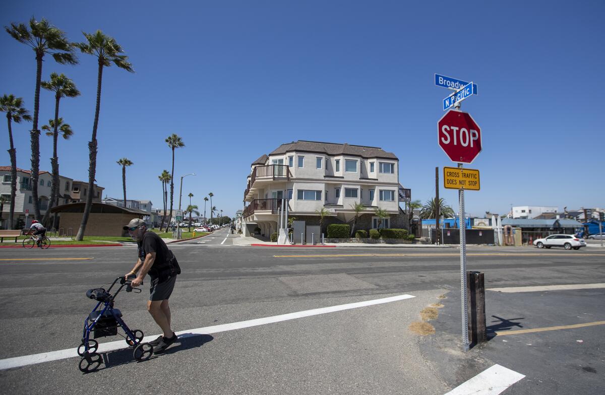 A pedestrian crosses the street at North Pacific and Broadway in Sunset Beach.