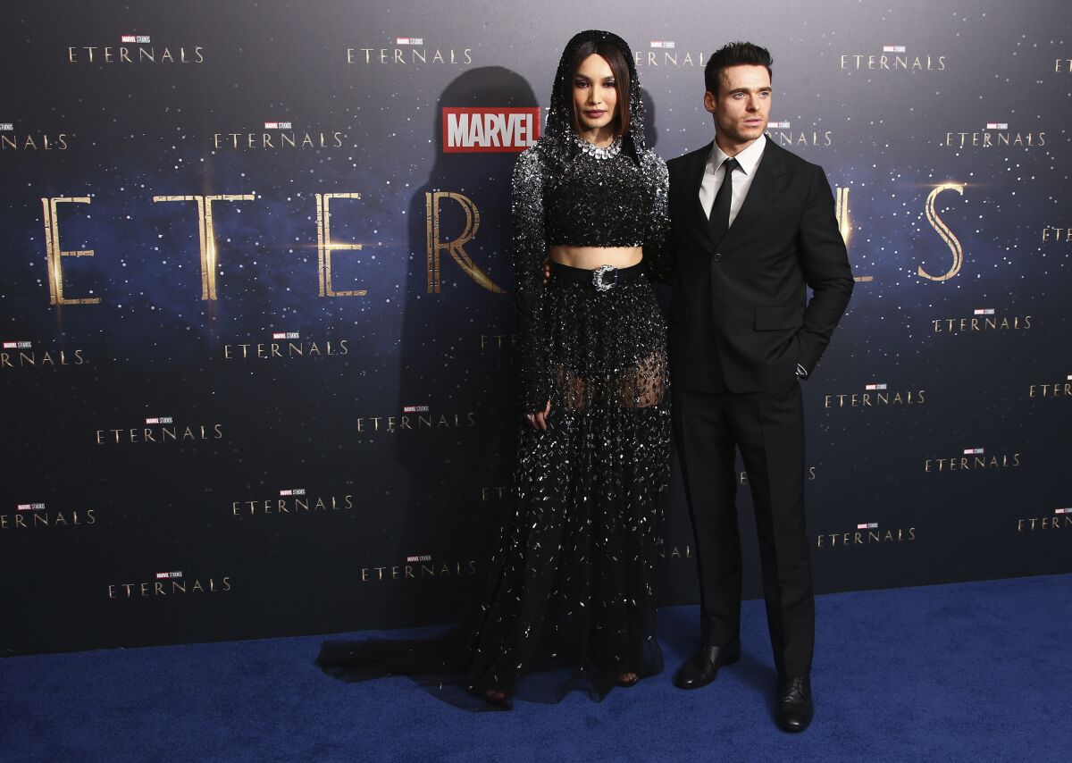 Gemma Chan, left, and Richard Madden pose for photographers upon arrival at the premiere of the film 'Eternals' on Wednesday, Oct. 27, 2021, in London. (Photo by Joel C Ryan/Invision/AP)