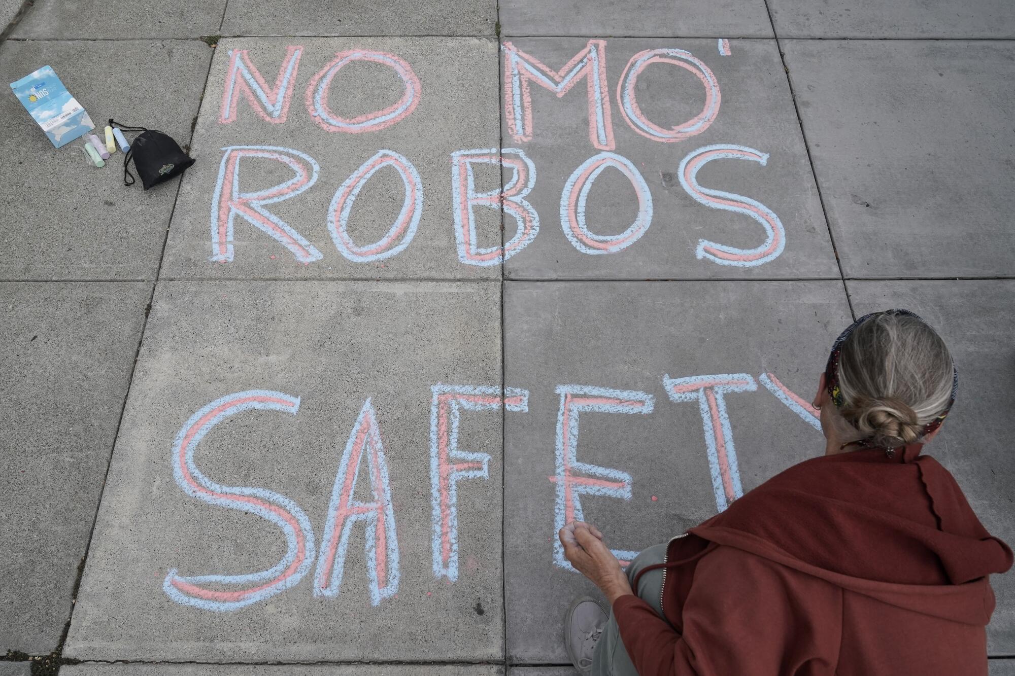 Martha Hubert writes a message opposing robotaxi expansion on Aug. 10 in San Francisco.