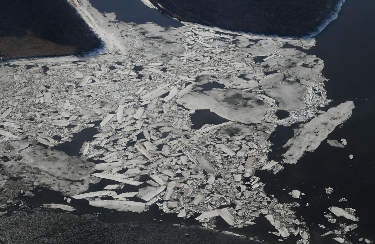 A aerial view of broken and melting ice on a river