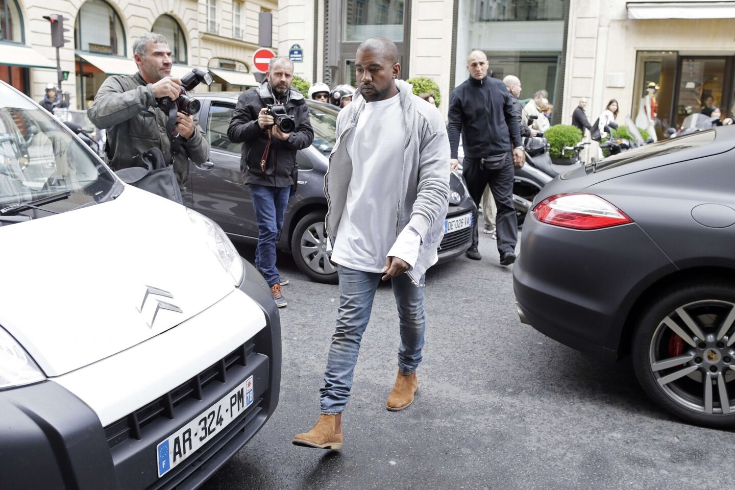 Kanye West crosses the street after getting out of a car in Paris on May 22.