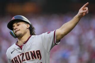 Arizona Diamondbacks' Alek Thomas celebrates after scoring on a hit by Evan Longoria.