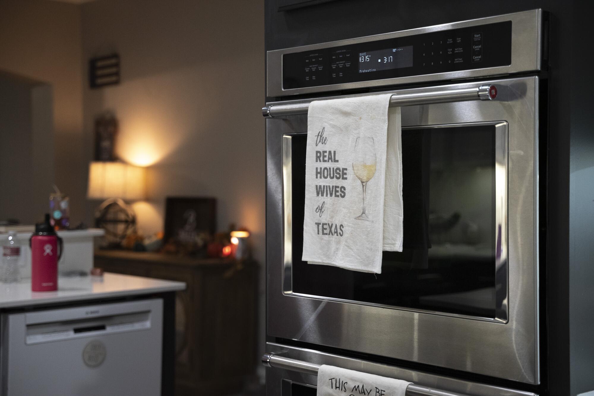 An oven with a kitchen towel hanging from its door.