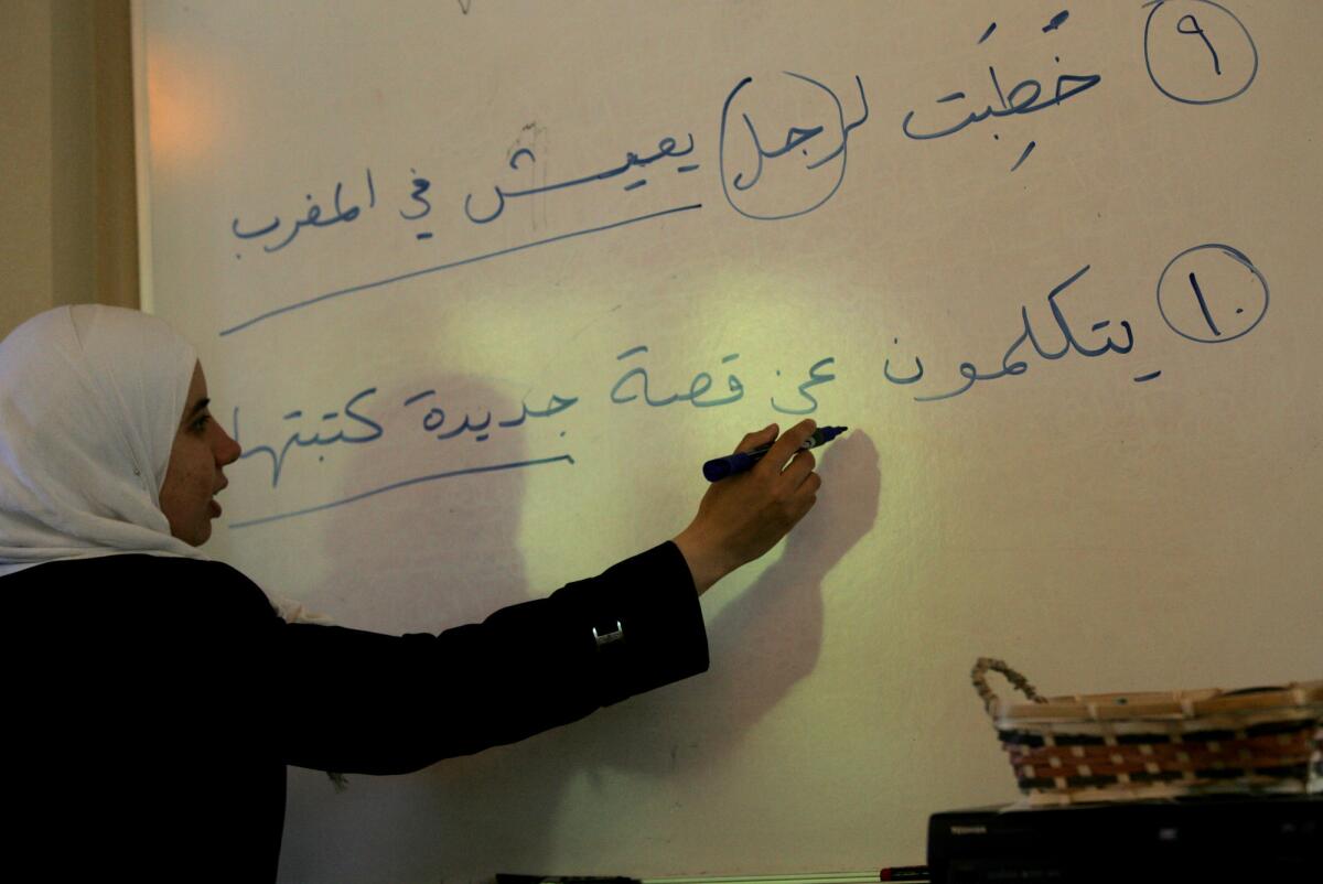 Professor Nawar Taleb-Agha writes a sentence on a whiteboard for Zaytuna students in Berkeley who are taking an intensive study of Arabic.