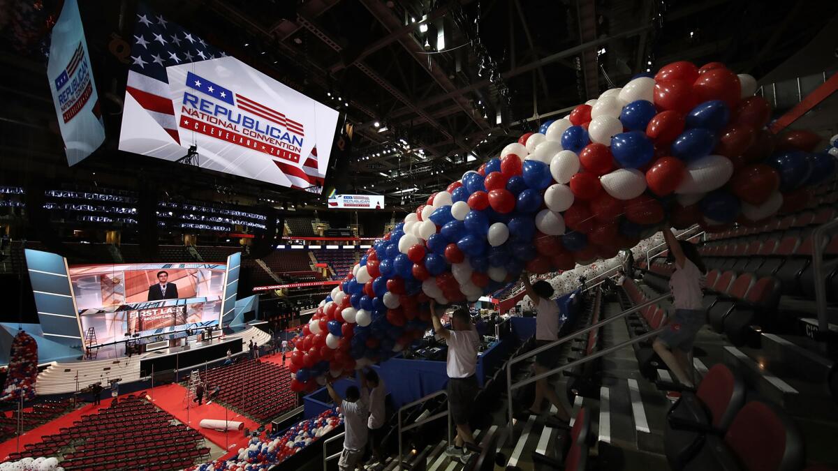 Volunteers position some of the more than 150,000 red, white and blue balloons to be dropped from the ceiling during the Republican National Convention in Cleveland.