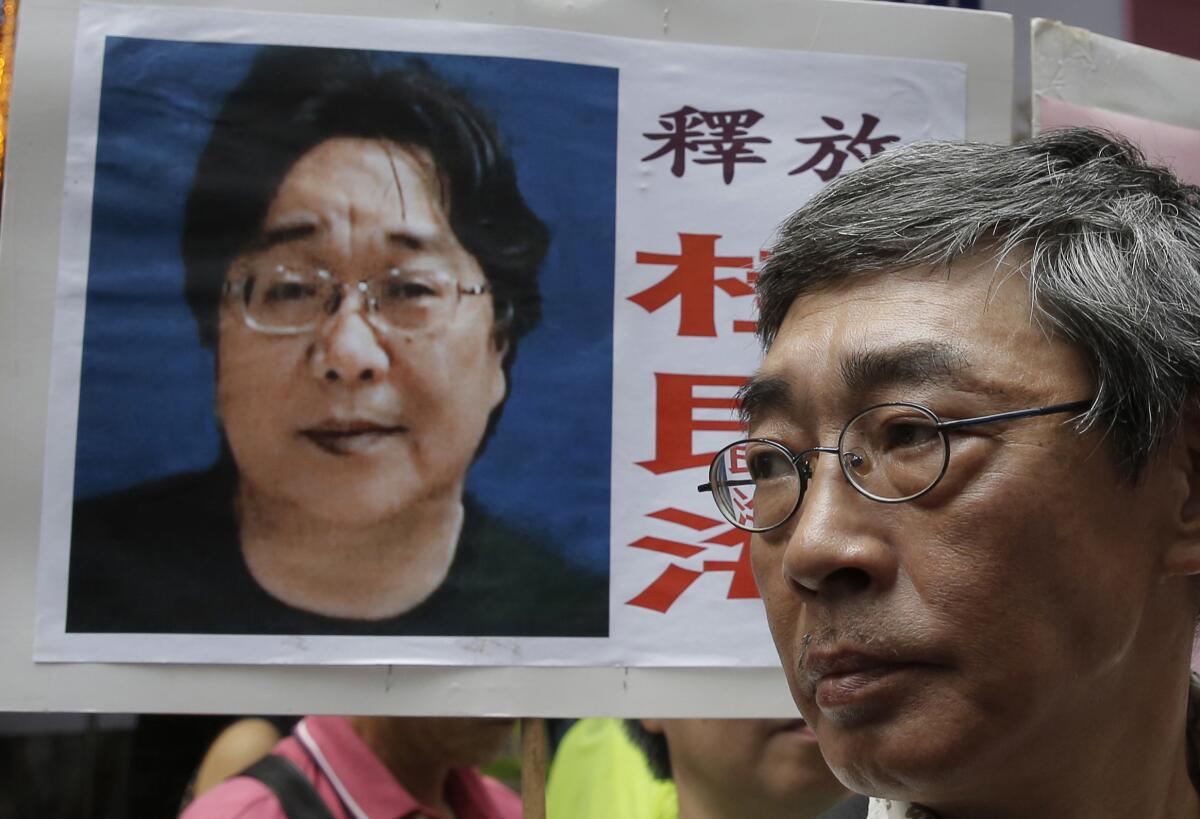 A placard bearing an image of Swedish bookseller Gui Minhai serves as a backdrop for freed Hong Kong bookseller Lam Wing-kee during a June 2016 march to the Chinese government's liaison office in Hong Kong.