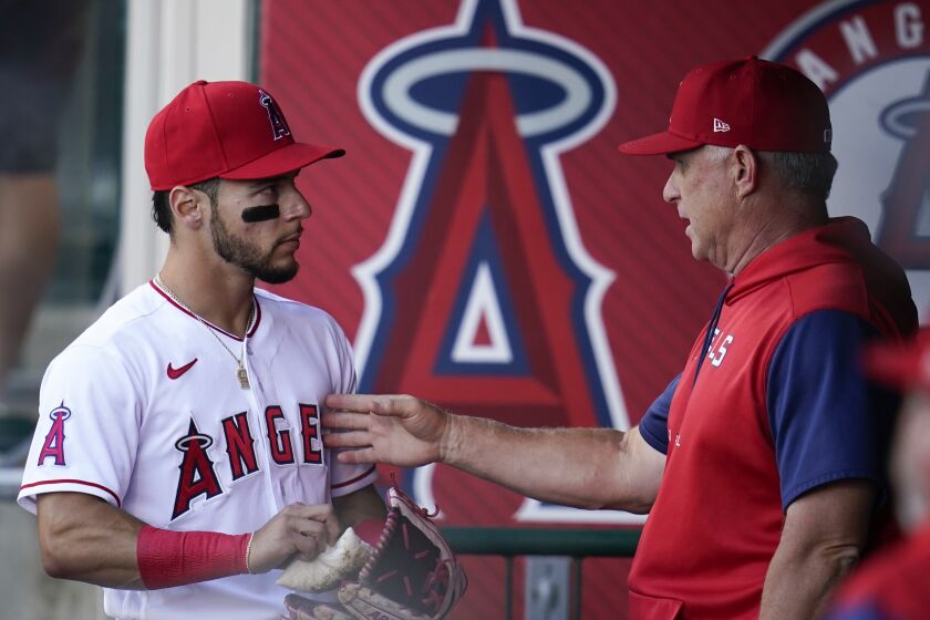 Los Angeles Angels shortstop Andrew Velazquez, left, talks with interim manager Phil Nevin in the dugout before a baseball game against the Boston Red Sox in Anaheim, Calif., Tuesday, June 7, 2022. (AP Photo/Ashley Landis)