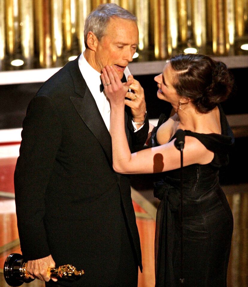 Presenter Julia Roberts wipes her lipstick kiss off Clint Eastwood's face as he accepts his Oscar for director for "Million Dollar Baby," during the 77th Academy Awards.