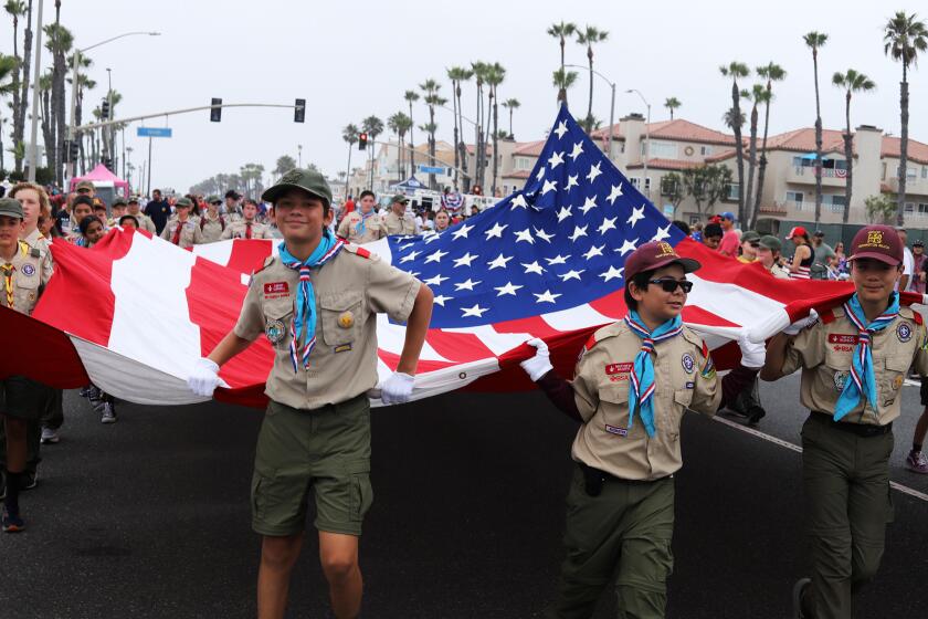 Scout troops of Huntington Beach hold the historic Freedoms Flag for the start of Huntington Beach's 120th Annual 4th of July Parade along Pacific Coast Highway in Huntington Beach on Thursday, July 4, 2024. (Photo by James Carbone)