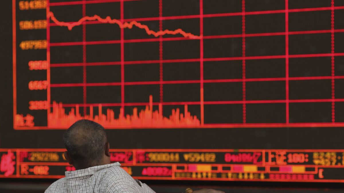 A Chinese investor watches as the Shanghai Composite Index falls at a brokerage in Beijing on Monday after President Trump's threat of more China tariffs.