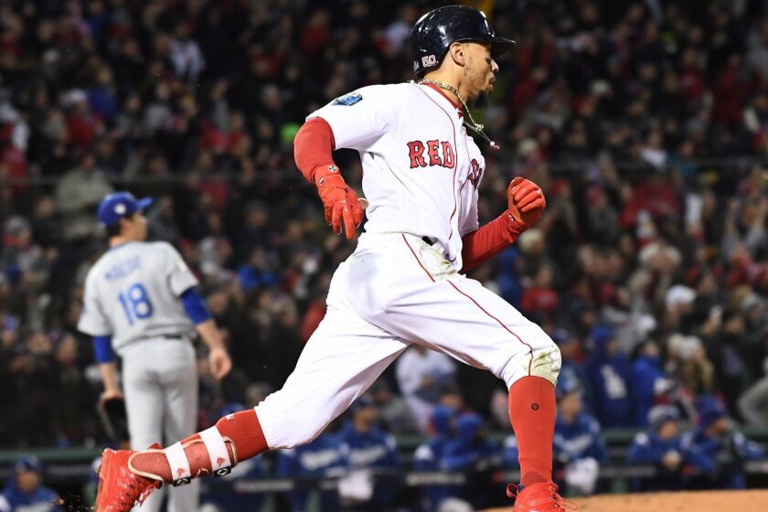 BOSTON, MA WEDNESDAY, OCTOBER 24, 2018 As Dodger pitcher Kenta Maeda looks on, Red Sox Mookie Betts hits a double in the 7th inning of game two of the World Series at Fenway Park.
