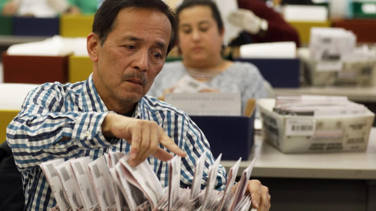 Workers at the Los Angeles County Registrar-Recorder/County Clerk office review ballots Tuesday in Norwalk.
