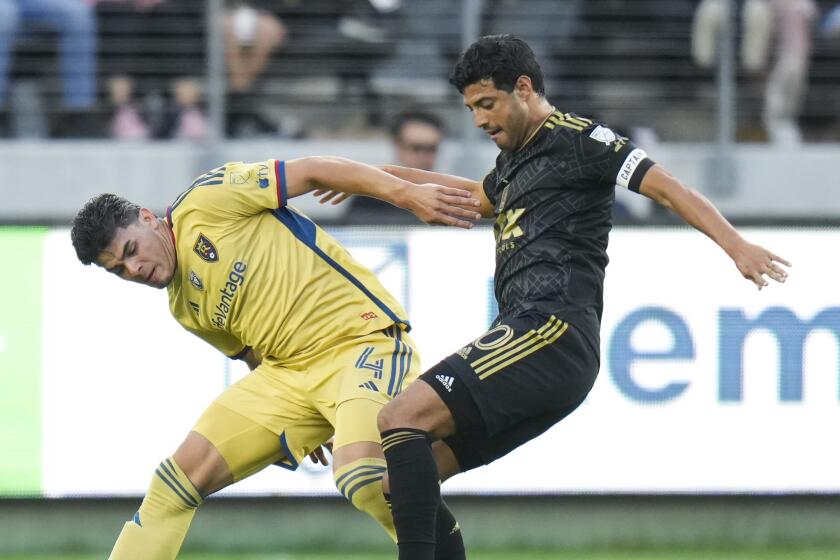 Los Angeles FC forward Carlos Vela, right, dribbles under pressure by Real Salt Lake.