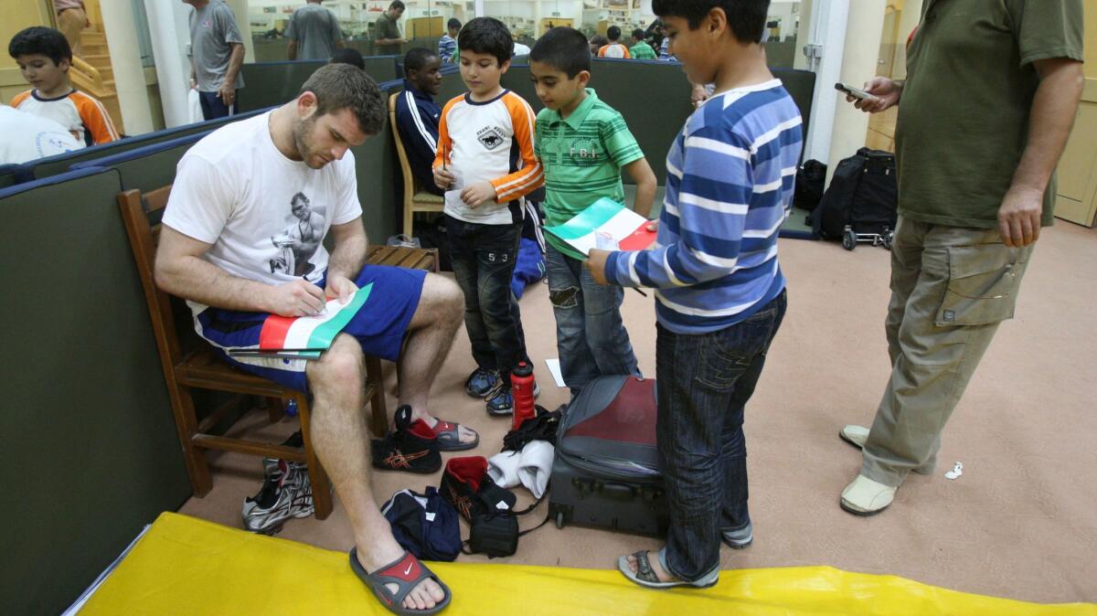 U.S. freestyle wrestler Daniel Bergman signs Iranian flags for Iranian boys during the Takhti Wrestling Cup, on the Persian Gulf island of Kish, Iran, in 2011.