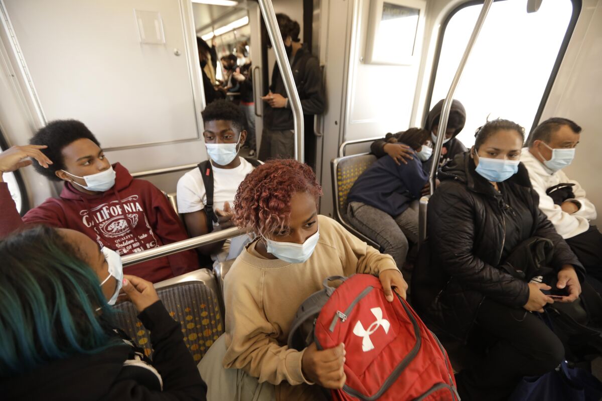 Students on a bus wear masks