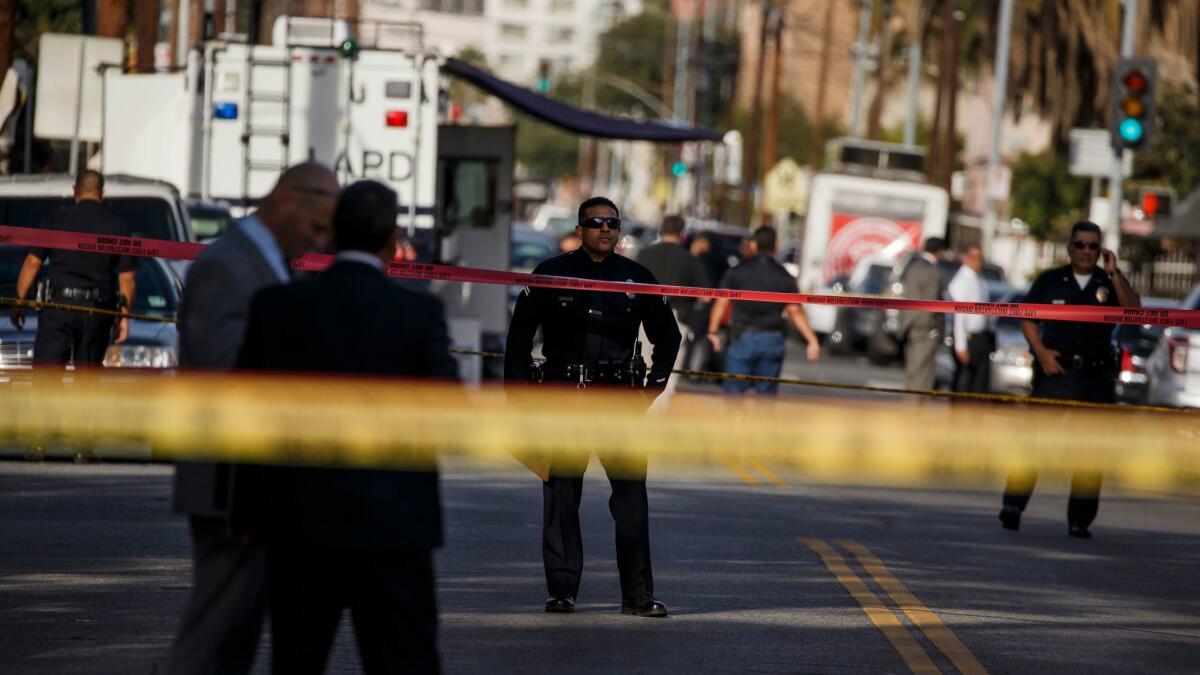 Investigators on Monday examine the South L.A. scene where a Los Angeles police officer fatally shot a man, described as being in his 20s, near Maple Avenue and 27th Street.