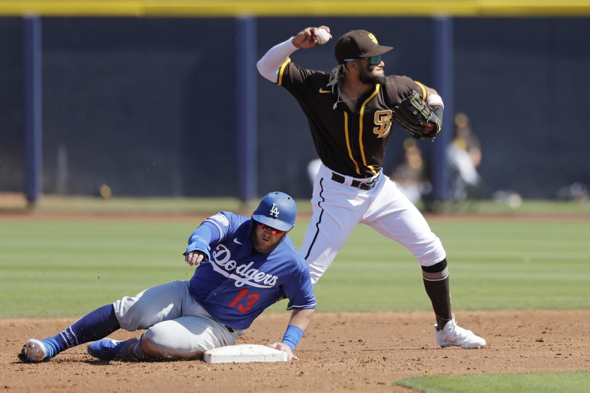 Padres shortstop Fernando Tatis Jr., right, turns to throw to first base for a double play after forcing out the Dodgers' Max Muncy at second base in the third inning of a spring training game.