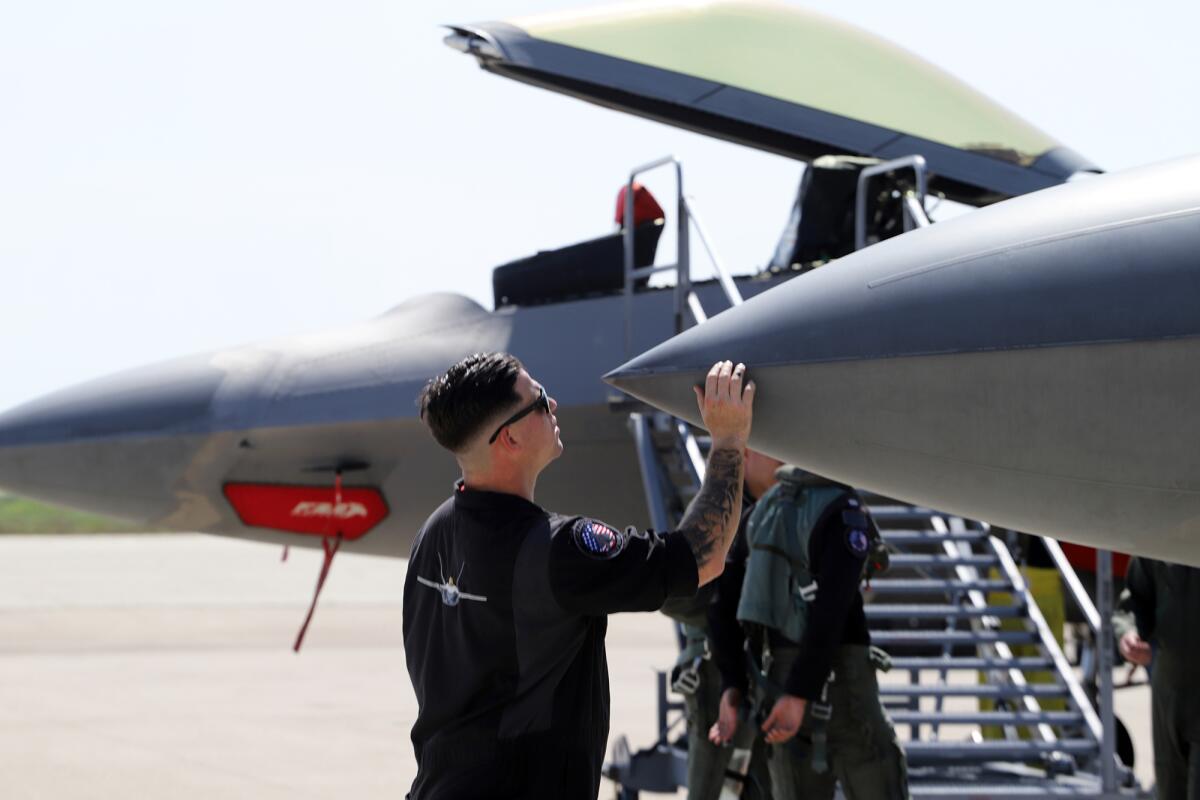 Air Force ground crew inspects the F-22 Raptor aircraft in Los Alamitos on Thursday.