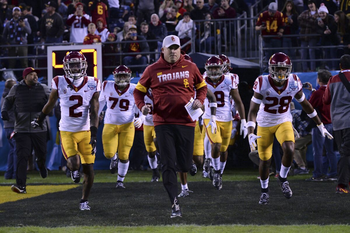 USC football coach Clay Helton leads his players onto the field before a game.