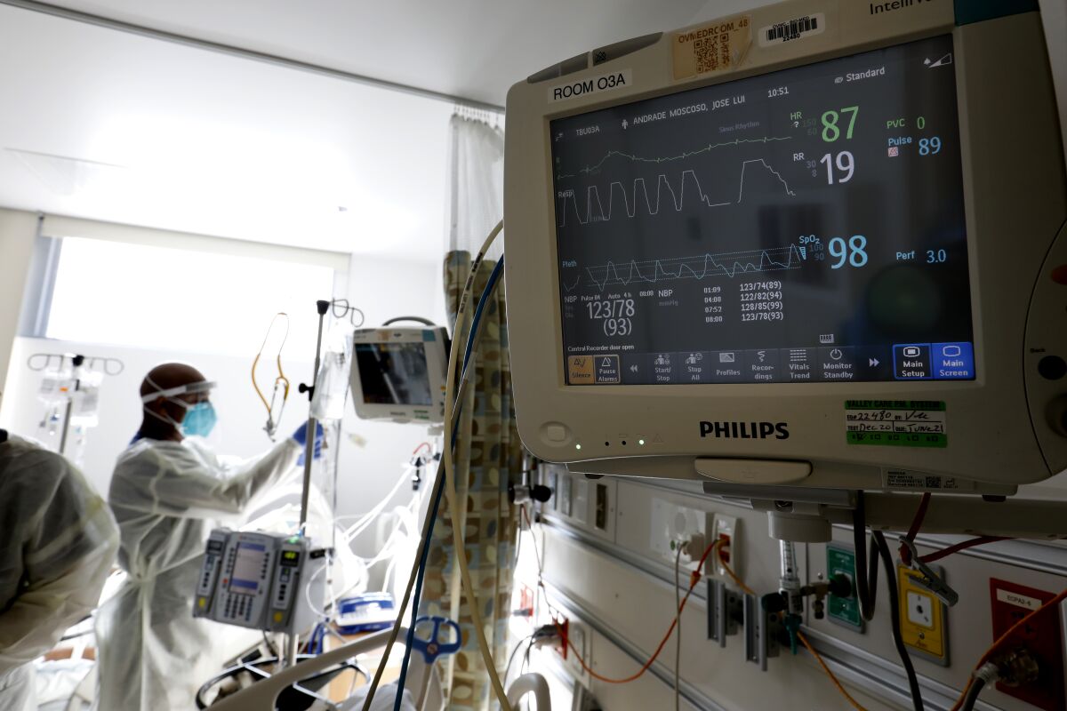 A nurse checks on patients in the COVID-19 wing at Olive View-UCLA Medical Center.
