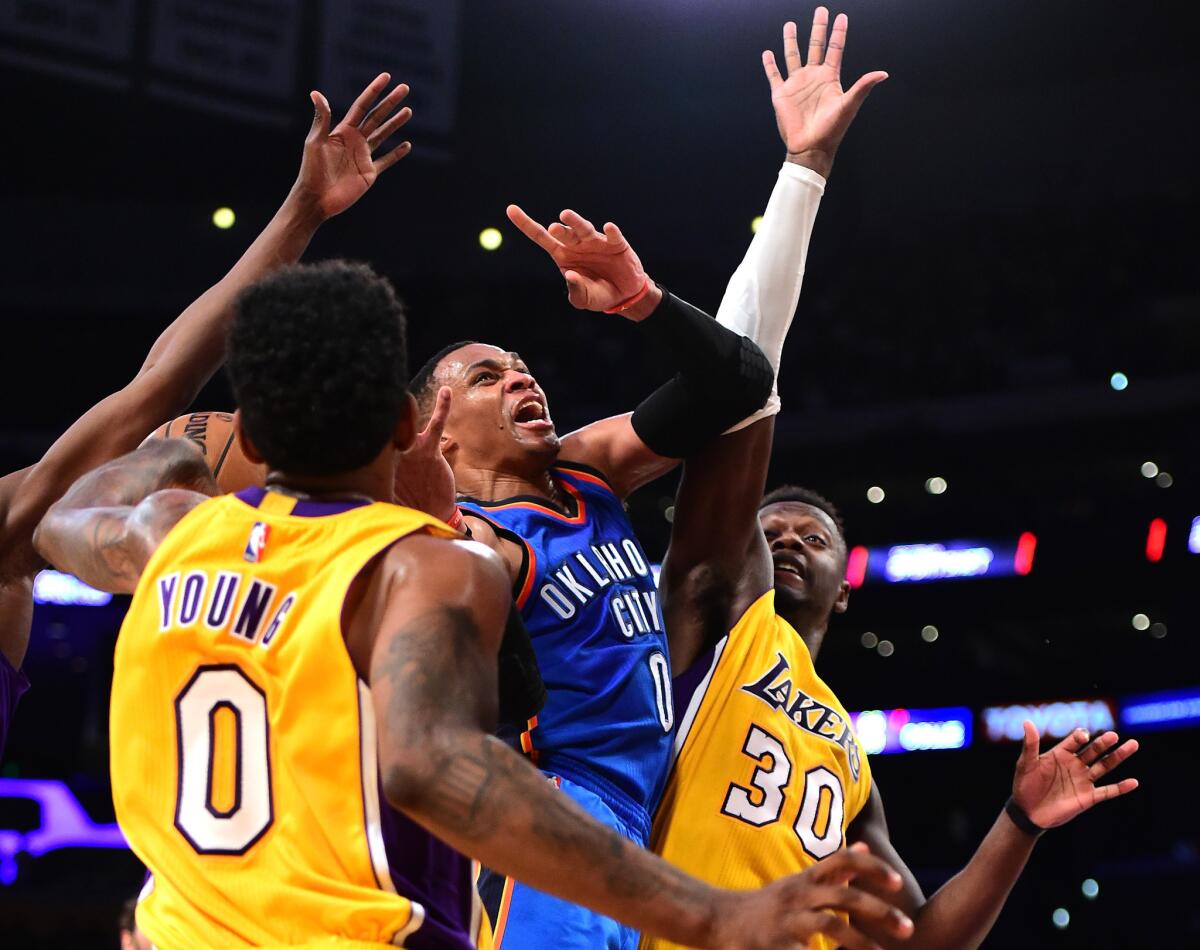 Thunder point guard Russell Westbrook (0) loses the ball between Lakers defenders Nick Young (0) and Julius Randle (30) during the first half on Tuesday.