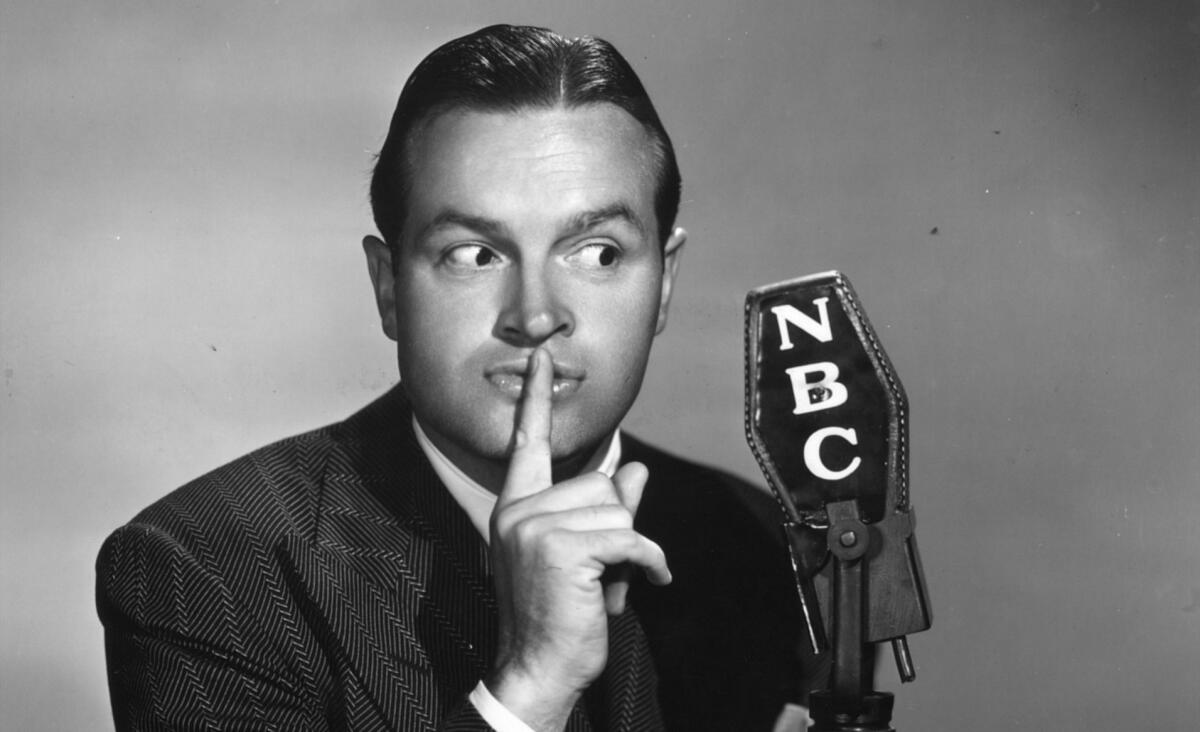 A 1947 photo of Bob Hope holding an NBC-emblazoned microphone.