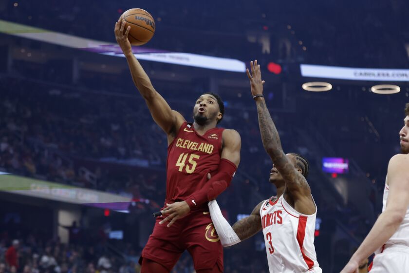 Cleveland Cavaliers guard Donovan Mitchell (45) shoots against Houston Rockets guard Kevin Porter Jr. (3) during the first half of an NBA basketball game, Sunday, March 26, 2023, in Cleveland. (AP Photo/Ron Schwane)