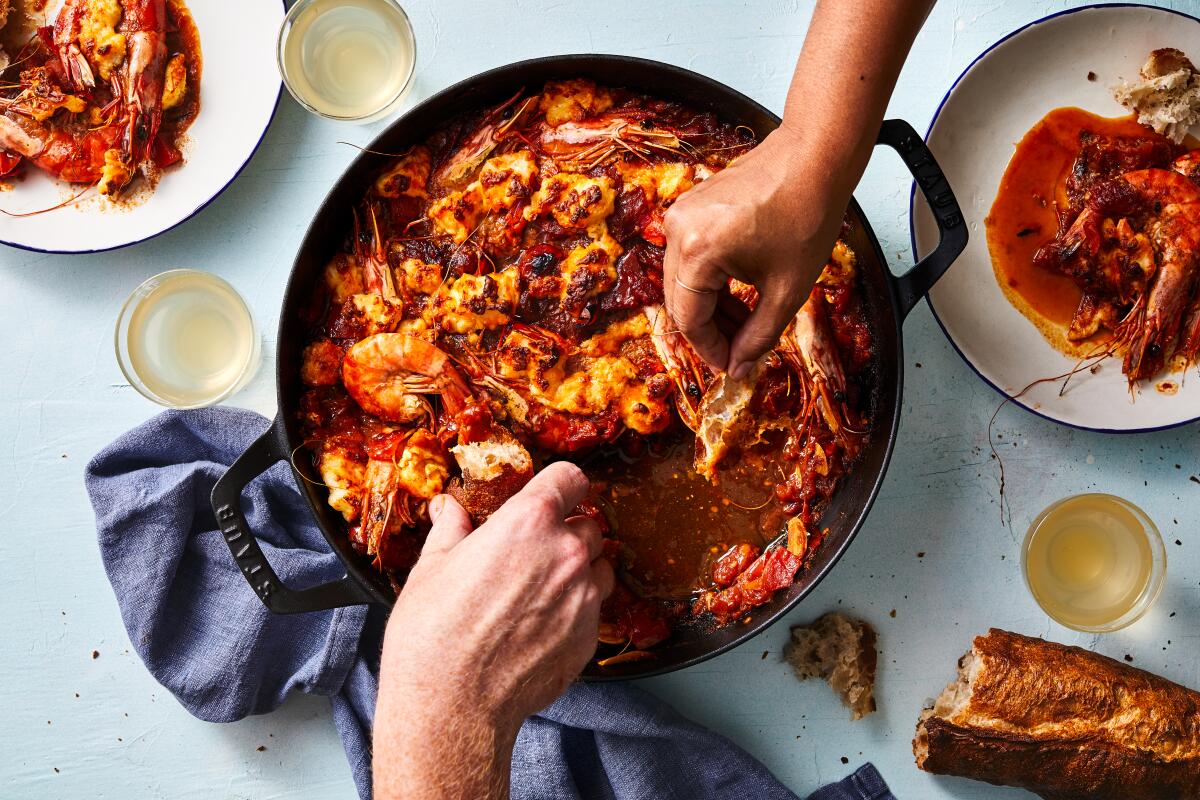 Shrimp saganaki — whole shrimp cooked in a spicy tomato sauce and topped with halloumi — makes a great one-pot dish to serve family style and for dragging bread through all the flavorful sauce. Prop styling by Nidia Cueva.