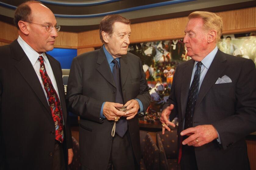 From left, longtime Kings announcer Bob Miller, legendary Lakers announcer Chick Hearn and Dodgers broadcaster Vin Scully talk before a show for Fox Sports in December 2000.