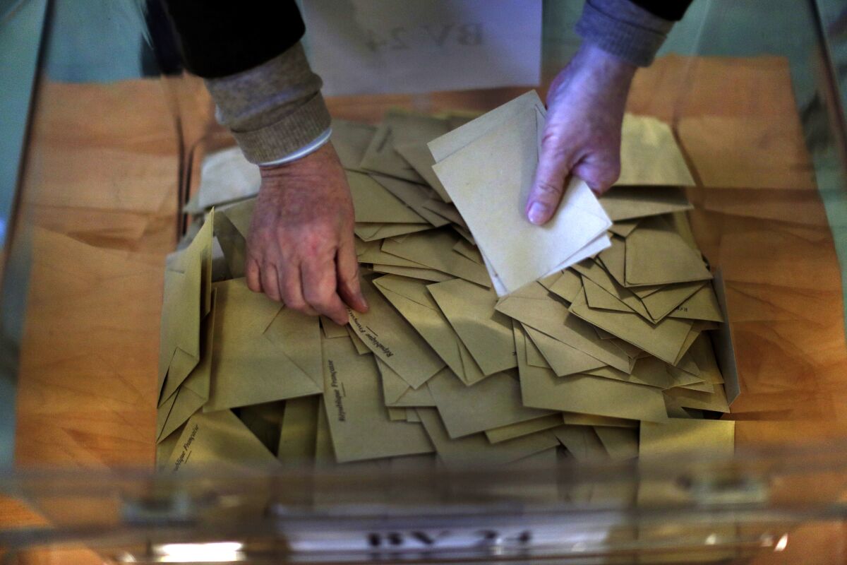 FILE - Ballots are counted by an election official for the first-round presidential election at a polling station in Paris, Sunday, April 23, 2017. (AP Photo/Emilio Morenatti, FILE)