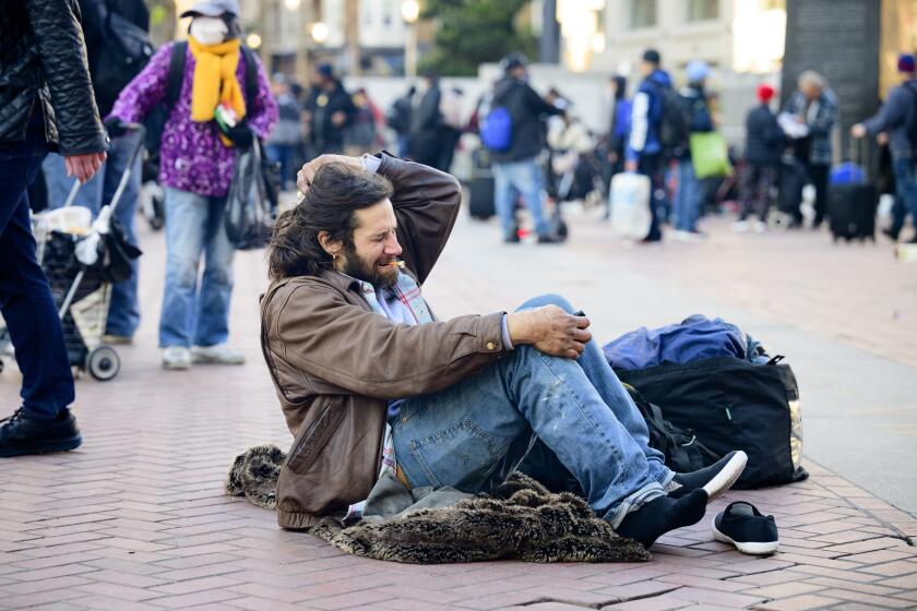 SAN FRANCISCO, CA - DECEMBER 17, 2022 - Drug user Rich McHugh smokes after falling down at UN Plaza in San Francisco, California on December 17, 2022. Dozens of people consume fentanyl, meth and other illegal substances in public near the site of a recently closed safe consumption site. (Josh Edelson/for the Times)