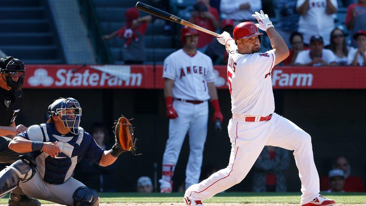 Angels designated hitter Albert Pujols hits a a two-run single in the ninth inning against the Seattle Mariners on Sunday.