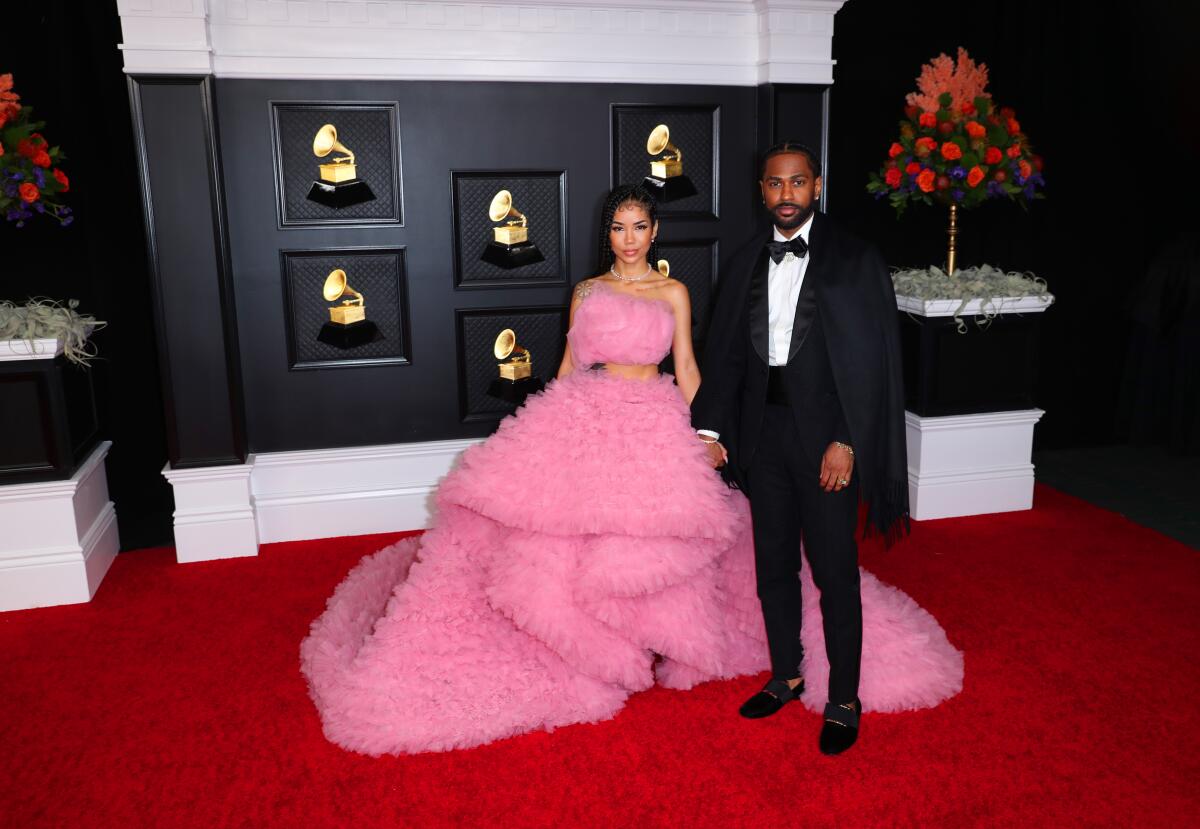 Woman in a pink dress and man in a tux on the red carpet 