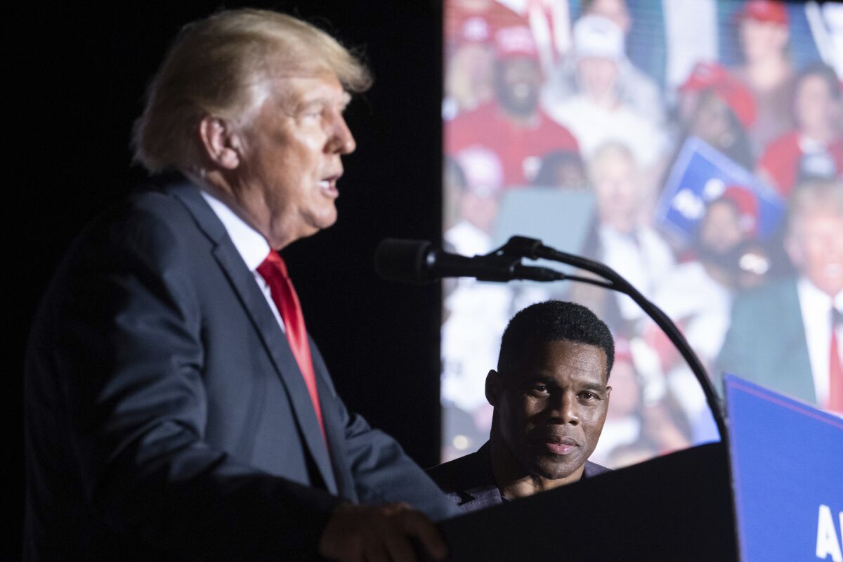 Former President Donald Trump speaks as Georgia Senate candidate Herschel Walker listens during his Save America rally in Perry, Ga., on Saturday, Sept. 25, 2021. (AP Photo/Ben Gray)