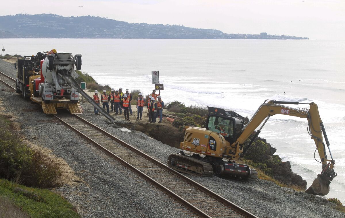 Workers repair the site of a bluff collapse next to the railroad tracks in Del Mar in late November.