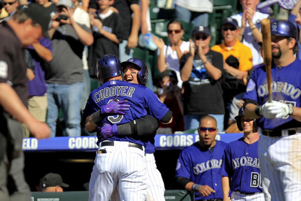 Colorado Rockies' Michael Cuddyer hugs teammate Troy Tulowitzki after Cuddyer hit a two-run homer to tie the game during the seventh inning.