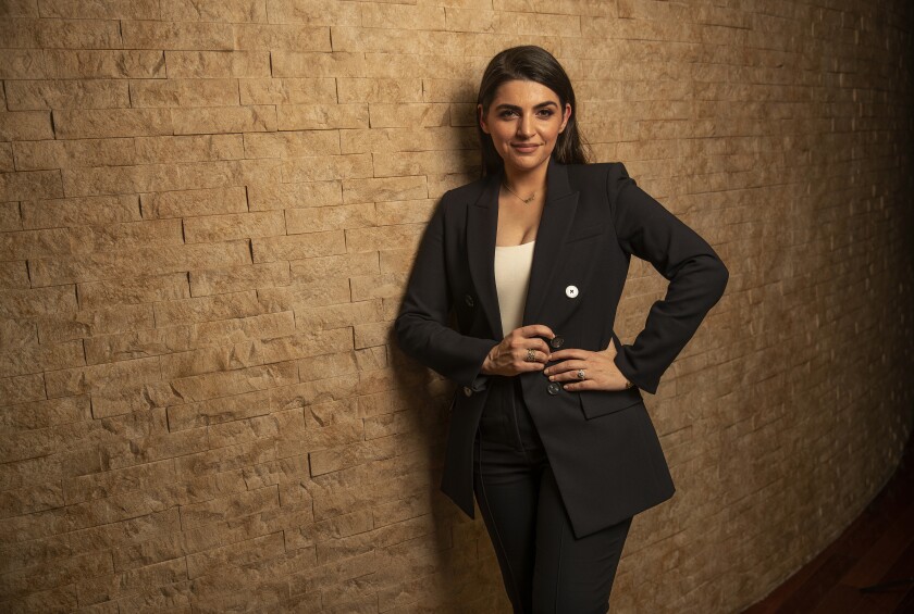 Sahar Sanjar Dejban leans against a brick wall.